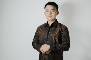 Portrait of Asian man wearing Indonesian traditional Batik cloth on white background