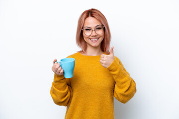 Wall Mural - Young Russian girl holding cup of coffee isolated on white background with thumbs up because something good has happened