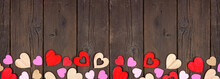 Valentines Day Bottom Border Of Wooden Hearts. Top View On A Dark Wood Banner Background. Copy Space.