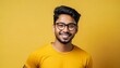 attractive indian man wearing yellow tshirt and glasses on yellow background
