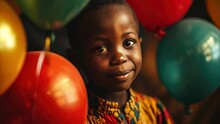 Cute African Boy With Red, Green And Yellow Balloons On Black Background. Panafrican Color. Black History Month.