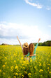 © maxbelchenko - Two young women in beautiful dresses walk in a field with yellow blooming rapeseed. Beautiful girlfriends enjoying the weather, having fun in a flowering field. Concept of fun, relaxation.