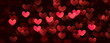 Red hearts valentine day defocused bokeh lights on a black background.