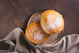Fototapeta  - Close up of sweet donuts with powdered sugar filled with boiled condensed milk top view
