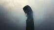  a woman standing in a foggy area with her head turned to the side and her hair blowing in the wind.