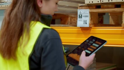 Canvas Print - Female warehouse worker holding scanner, scanning the barcodes on products in warehouse. Warehouse manager using warehouse scanning system.