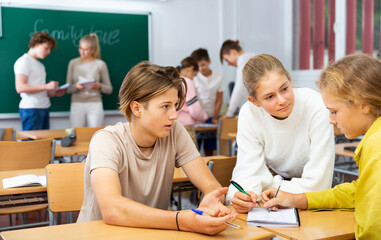 Wall Mural - Schoolchildren study together in group lessons in the school class