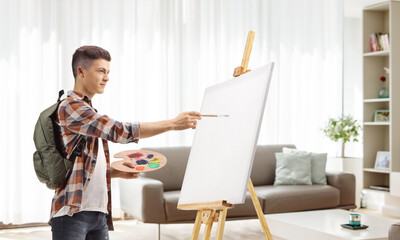 Wall Mural - Male student painting on a canvas