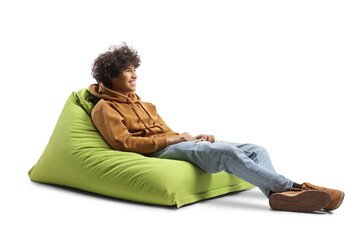 Sticker - Gen z guy sitting on a green bean bag chair and smiling