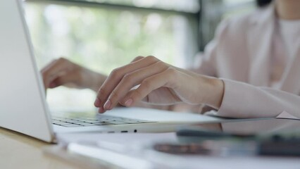 Close up Female hands typing on laptop at desk, close up view,Copywriter writing text on computer keyboard in coffeeshop.