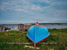 Upside Down Blue And Red Rowboat On A Grassy Piece Of Land On Fogo Island In Newfoundland-Labrador