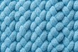Close up of blue knitted fabric with a textured pattern made of angora or wool