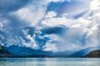Annecy, France - September 21 2020 : panorama of the calm and idyllic mountain lake of Annecy with crystal clear water and a cloud formation