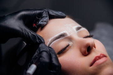 The makeup artist performs permanent makeup. Professional makeup and facial care. Eyebrow and lip tattooing. Cosmetologist. Beauty salon.