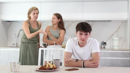 Wall Mural - Upset guy dont speaking after discord with mother and young wife standing behind