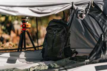 tents pitched on hillsides beside streams of water from waterfalls. hiking bag in tent.