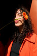 © Westend61 - Smiling woman making puckering face with gerbera flower in front of wall