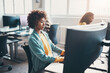 © Flamingo Images - Young businesswoman and colleagues sitting in an office and working on computers