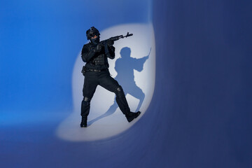 Wall Mural - Soldier in black uniforms with weapon in studio. Concept Military warrior army tactical force to fight crime in city