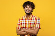 Young smiling happy cheerful Indian man he wearing shirt casual clothes look camera hold hands crossed folded look camera isolated on plain yellow color background studio portrait. Lifestyle concept.