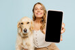 Young owner woman with her best friend retriever wear casual clothes use blank screen area mobile cell phone hug dog isolated on plain pastel light blue background studio. Take care about pet concept.