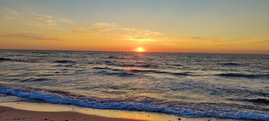 Beautiful sunset at the coastline with orange colors in the sky