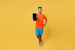 Full body young fitness trainer sporty man sportsman wear orange t-shirt hold blank screen mobile cell phone spend time in home gym isolated on plain yellow background. Workout sport fit abs concept.