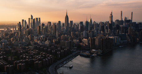  New York City Aerial Evening Cityscape with Stunning Manhattan Landmarks, Skyscrapers and Residential Buildings. Long Wide Angle Panoramic Helicopter View of a Popular Travel Destination