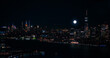 Scenic Aerial New York City Night View of Manhattan Architecture and Big Shining Full Moon. Panoramic Financial District Photo from a Helicopter. Cityscape with Office Buildings and Skyscrapers