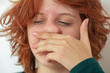 teenage girl wipes droplets from her nose after sneezing