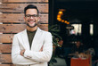 © Dorde - Happy smiling confident male leader businessman standing outside the modern city restaurant looking at camera with arms crossed. Business successful executive concept. Portrait.