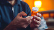 close up of man at home sitting down handling prescription pill bottle