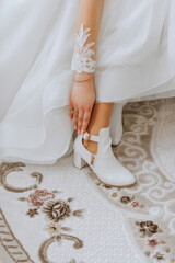 close up view of woman putting on shoes. The bride puts on her shoes before the wedding ceremony. Detail of the bride putting on her wedding shoes. Shoes of the bride for the wedding.