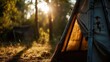 A tent illuminated by the sun's rays filtering through the trees. Ideal for camping, outdoor adventure, and nature-themed designs