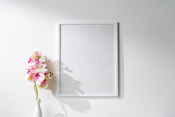 Wall Mural - White wooden frame on white wall above the table