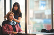 © chokniti - Asian Hairdresser giving treatment and barber occupation service, Professional hairstylist combing and using scissors cut woman's hair to young beautiful customer girl in beauty salon