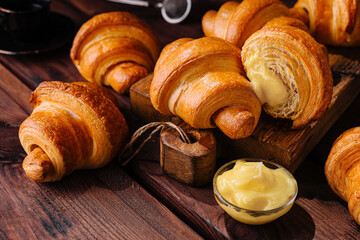 Wall Mural - Appetizing croissants on wooden table close-up