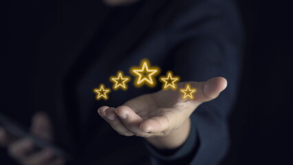 Wall Mural - hand of customer or client holding the stars to complete five stars. with copy space. giving a five star rating. Service rating, satisfaction concept.