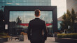 Full back view of successful business man owner in suit standing in front of modern office.