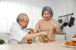 © offsuperphoto - senior couple enjoy cooking and eating salad in the kitchen