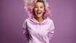 Isolated on a purple background, a happy, attractive young woman in the Gen Z style with short blond hair, a cute smile, and shoes, pants, and a pink sweater, is dancing and bouncing