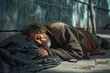 Homeless man sleeping on the street, on the asphalt in winter 