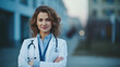 © SkyLine - Young confident female doctor stands outdoors, her pose casual yet assured, representing accessibility and approachability of modern healthcare professionals. Concept of healthcare and medical care