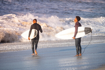 Wall Mural - Surfers entering the ocean