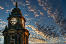 Historic Clock Tower Silhouette Against A Dramatic Sunset Sky With Scattered Clouds In Lancaster.