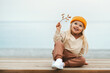 © EVERST - Child girl happy smiling outdoor walking on the beach kid 4 years old in yellow hat family travel vacations autumn season