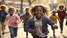 Happy African American Schoolchildren Running Through The School Yard Summer