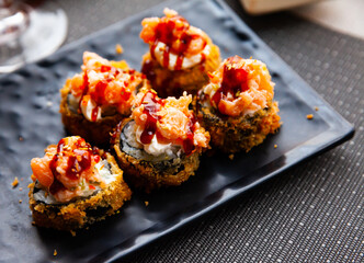 Wall Mural - Hot fried futomaki topped with chopped salmon and delicate cream cheese. Traditional Japanese sushi