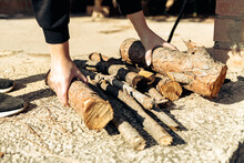 Person Organizing Firewood On Concrete Ground