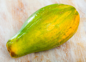 Wall Mural - Closeup of fresh ripe papaya fruit on wooden background